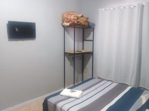 una camera con un letto e una mensola con asciugamani di Apto confortável com Churrasqueira 03 a Cachoeira do Sul