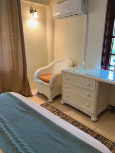 1 dormitorio con tocador y silla con espejo en Apartment Ellie, en Castries