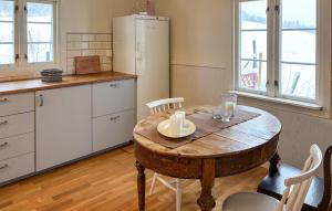 Una cocina con una mesa de madera y un refrigerador. en Cozy Home In Oppdal With House A Mountain View, en Fagerhaug
