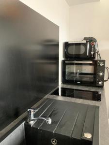 eine Mikrowelle auf einem Herd in einer Küche in der Unterkunft Family retreat in the middle of nature Font Romeu in Égat