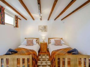 two beds in a room with white walls and wooden ceilings at 2 Bed in Hexham 88443 in Acomb