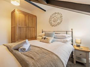 ein Schlafzimmer mit einem großen Bett mit einem hölzernen Kopfteil in der Unterkunft 4 Bed in Rosthwaite 86392 in Rosthwaite