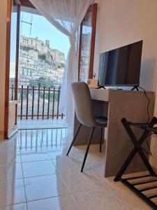 Giardino San Gerardo Maiella vista Castello e con parcheggio interno privato في Muro Lucano: مكتب فيه كمبيوتر وتلفزيون في الغرفة
