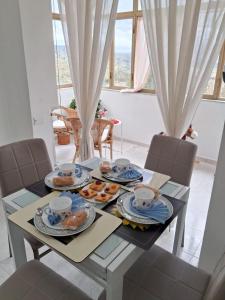 Giardino San Gerardo Maiella vista Castello e con parcheggio interno privato في Muro Lucano: طاولة طعام مع أطباق من الطعام عليها