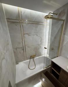 a bathroom with a shower and a tub and a sink at Apartament pod Krasnalem in Wrocław