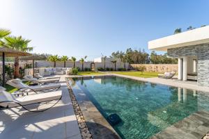 a swimming pool with lounge chairs next to a house at DAR PITXI - Personnel inclu in Essaouira