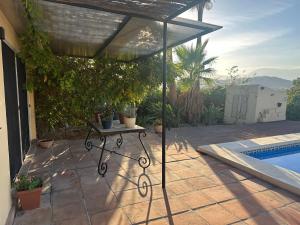 eine Terrasse mit einem Tisch neben einem Pool in der Unterkunft Casitas Andalucia in Malaga