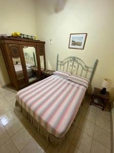 een bed met een gestreepte deken in een kamer bij Lugar para Relajarse in Duggan