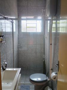 un bagno con doccia, wc e lavandino di Apto confortável com Churrasqueira 03 a Cachoeira do Sul