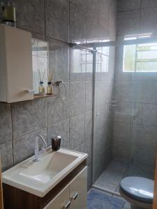 un bagno con doccia, lavandino e WC di Apto confortável com Churrasqueira 03 a Cachoeira do Sul