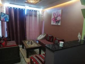 阿加迪尔Chez Maryam , pour les familles à 10 minutes de la plage的客厅里有一张沙发和一张桌子。 更多9张照片