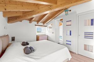 Casa in Centro في بروتونيغلا: غرفة نوم بسرير ابيض عليها منشفتين