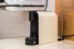 a coffee machine sitting on a counter next to a microwave at Apartment T1 - Porto in Porto +5 photos