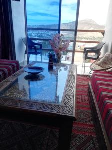 阿加迪尔Chez Maryam , pour les familles à 10 minutes de la plage的带桌子和大窗户的客厅