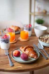 Una mesa con un plato de croissants y fruta encima. en L'Olivier, en Touët-sur-Var