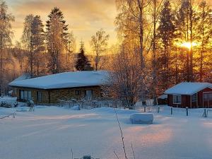 una casa ricoperta di neve con il sole sullo sfondo di Aurora house a Rovaniemi