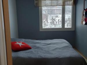 una camera da letto con un cuscino rosso su un letto con finestra di Aurora house a Rovaniemi