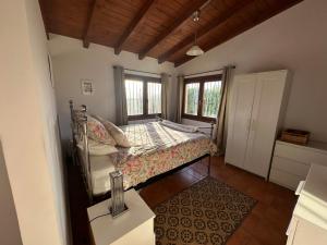 ein Schlafzimmer mit einem Bett in einem Zimmer mit Fenstern in der Unterkunft Casitas Andalucia in Malaga