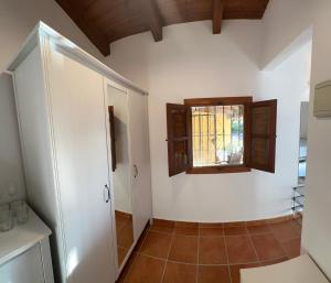 ein Badezimmer mit weißen Wänden, einem Fenster und Fliesenboden in der Unterkunft Casitas Andalucia in Malaga + 25 Fotos