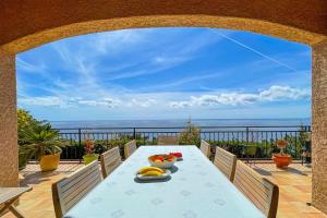 Sea-view villa for 11 guests with a heated infinity pool في سانت رافائيل: طاولة عليها فاكهة على شرفة