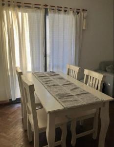 mesa blanca y sillas con mesa y ventana en Dpto Nueva Cordoba, en Córdoba