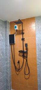 eine Dusche in einem Bad mit einem Schlauch, der an eine Wand angeschlossen ist in der Unterkunft Modern Bungalows in Ko Lanta Yai