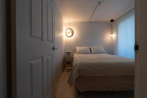 Un dormitorio con una cama y un reloj en la pared. en Sogonhouse, en Seúl 37 fotos más