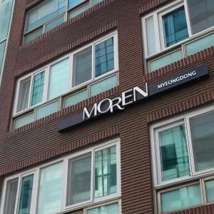uma placa na lateral de um prédio de tijolos em MOREN Seoul Myeongdong em Seul