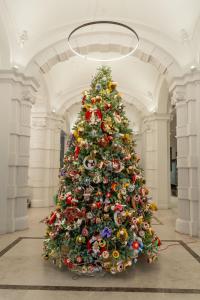 ein großer Weihnachtsbaum in einem Gebäude in der Unterkunft Hilton Garden Inn Bucharest Old Town in Bukarest