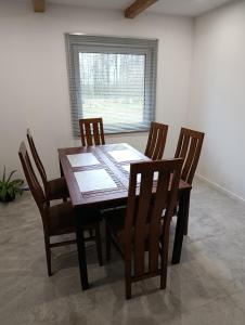 a dining room table with four chairs and a window at PokojeS12 in Chełm