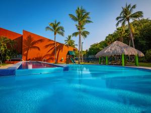 圣克鲁斯华特库Las Brisas Huatulco-All Inclusive的棕榈树环绕的建筑物前的游泳池