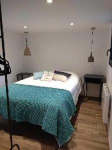 a bedroom with a bed with a green blanket at La Corentine in Bandol