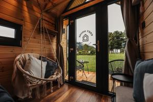 阿尔滕马克特蓬高Berg & Natur - Cozy house的小木屋里的秋千，配有露台门 更多37张照片