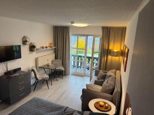 a living room with a couch and a table and a television at Gemütliche Ferienwohnung mit Blick auf die Donau in Obernzell