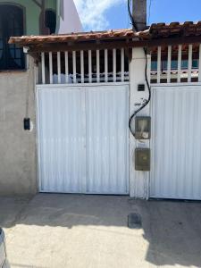 ein Paar weißer Tore vor einem Haus in der Unterkunft RM Hospedage Unidade Amapa 2 in Cabo Frio