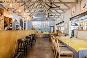 uma sala de jantar com mesas e cadeiras amarelas em Perry's Bridge Hollow Boutique Hotel em Hazyview