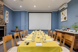 uma sala de conferências com uma mesa longa e um ecrã branco em Perry's Bridge Hollow Boutique Hotel em Hazyview mais 34 fotografias
