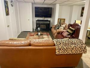 a living room with a brown leather couch and chairs at SylverPrud in Beauceville