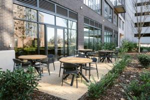 a group of tables and chairs in front of a building at Placemakr Huntsville - MidCity District in Huntsville