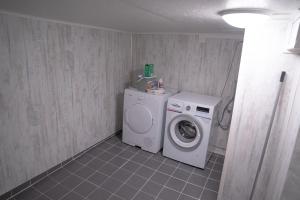 un lavadero con lavadora y lavadora en Beautiful little house which offers the best of Senja, en Gibostad