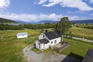 Una vista aérea de una casa blanca en un campo. en Beautiful little house which offers the best of Senja, en Gibostad