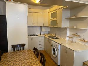 a kitchen with white cabinets and a table and chairs at family house in Aghk'ilisa