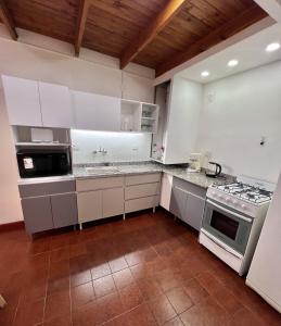 Amplio departamento renovado en el centro de la ciudad في إل كالافاتي: مطبخ بخزائن بيضاء وفرن موقد