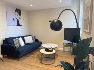 a living room with a blue couch and a tv at Studio Seven - Leeds City Centre in Central Station
