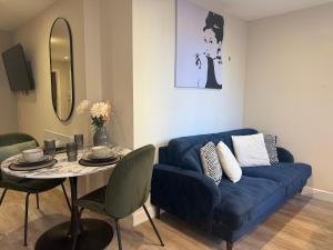 a living room with a blue couch and a table at Studio Seven - Leeds City Centre in Central Station