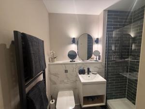 a bathroom with a sink and a toilet and a mirror at Studio Seven - Leeds City Centre in Central Station +17 photos