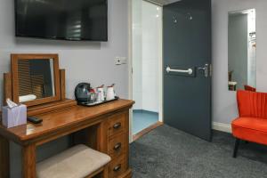 Zimmer mit einem Schreibtisch mit einem Spiegel und einem roten Stuhl in der Unterkunft Best Western Claydon Hotel in Ipswich