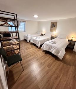 Amplio departamento renovado en el centro de la ciudad في إل كالافاتي: غرفة بها ثلاثة أسرة ورف كتاب