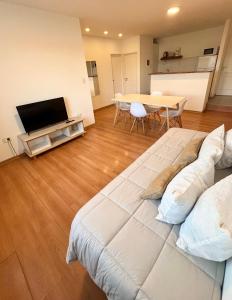 Amplio departamento renovado en el centro de la ciudad في إل كالافاتي: غرفة معيشة مع سرير كبير وطاولة