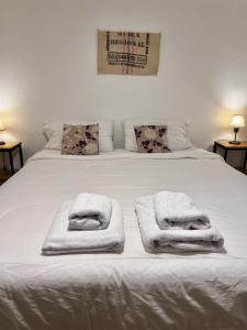 Amplio departamento renovado en el centro de la ciudad في إل كالافاتي: سرير ابيض عليه منشفتين +63 صورة